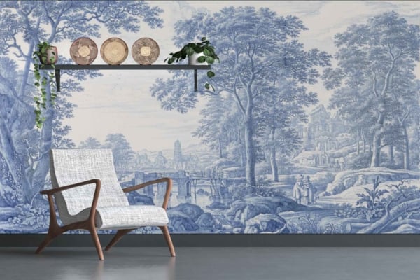 Scenic blue-and-white mural featuring a pastoral landscape with trees and distant mountains.