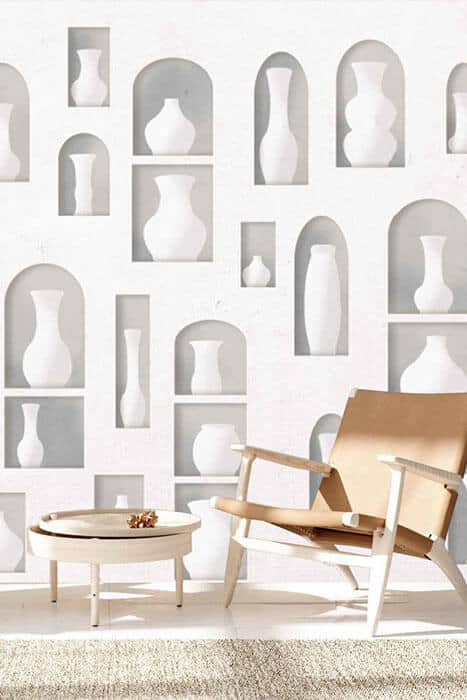 A minimalist room featuring white walls with a wallpaper pattern of delicate, muted grey lines forming a subtle geometric design.