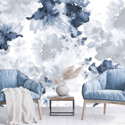 The wallpaper showcases a large floral mural in shades of blue and white, creating a calming ambiance. It features intricate patterns of blooming flowers, delicate petals, and twisting vines. The various tones of blue range from soft pastels to deep navy, interspersed with crisp white highlights that add depth and contrast. This elegant design evokes tranquility and serenity in the living room setting.