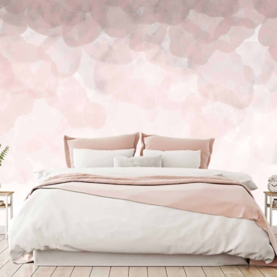 The wallpaper behind the bed features a gradient, abstract design with soft pink and petal hues. The colors blend seamlessly to create a serene ambiance. Hues of blush pink, pastel rose, and delicate whites dominate the pattern, creating a dreamy backdrop for the bedroom. Key elements include smooth transitions between shades and an overall soothing palette.