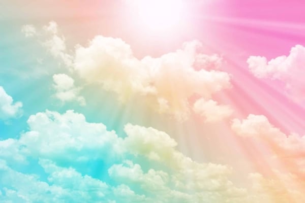 Wallpaper features fluffy white clouds, a bright sun with rays, gradient sky transitioning from vibrant blue to soft pink, and delicate hints of a rainbow. Dreamy and serene atmosphere.