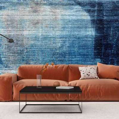 The wallpaper features a roughed-up, textured design with abstract art. It displays various shades of blue, including navy and sky blue, complemented by occasional strokes of white and hints of gray. Specks and scratches add to its distressed aesthetic.