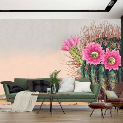 A modern living room wallpaper features a large mural of a cactus adorned with blooming pink flowers, incorporating elements of desert wilderness. Key colors include green from the cactus, vibrant pink from the flowers, and earthy tones.