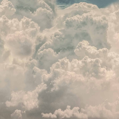 Wallpaper featuring a vast expanse of fluffy white clouds, varying textures and forms creating a dynamic and peaceful atmosphere. Soft, dense clouds dominate with slight hints of blue sky, suggesting a bright day.