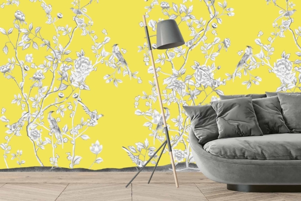 The vibrant yellow wall adorned with a white and grey floral and bird pattern evokes the elegance of Versailles.