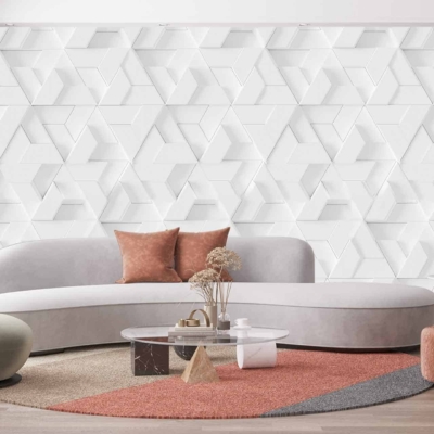 The modern living room features a white geometric Wonderwall wallpaper. The wallpaper's design showcases intricate patterns with sharp angles and clean lines in pure white hues. This sleek and contemporary backdrop adds a sophisticated touch to the room's ambiance, perfectly complementing the overall decor with its minimalist elegance.
