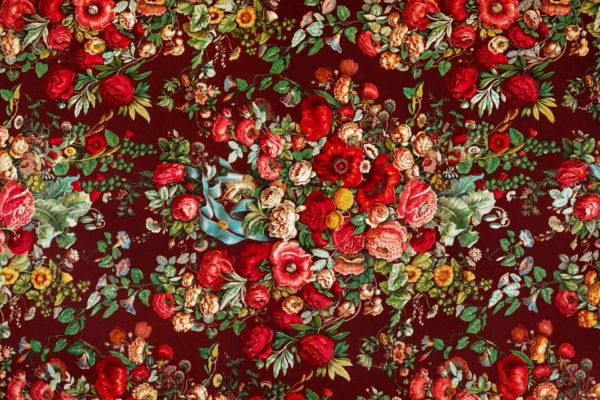 A vibrant floral wallpaper features an array of flowers in shades of red, pink, yellow, and white on a dark red background. Green leaves and intertwining stems enhance the detailed botanical design.