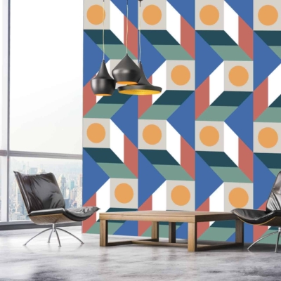 The wallpaper in the modern room features a vibrant and colorful geometric pattern. Elements include overlapping triangles, squares, and hexagons with hues of teal, mustard yellow, coral, navy blue, and white. The bold design contrasts with the sleek black leather chairs and wooden coffee table while adding a dynamic visual interest to the space.