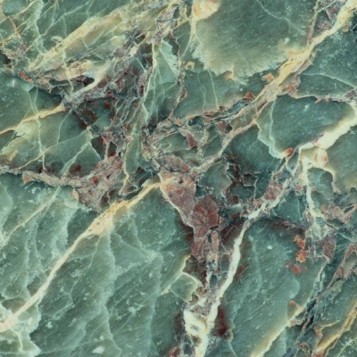 A close-up shot of a green marble surface showcases intricate veining patterns in shades of green, brown, and cream. The smooth, polished texture highlights the natural variations and complexities in the stone.