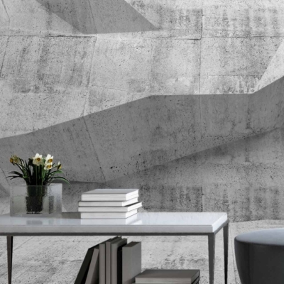 Textured, geometric concrete wall with various patterns and shades of gray.