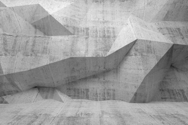 A monochromatic wallpaper featuring an abstract concrete wall with sharp, angular geometric shapes and varying depths. The surface is rough and textured, with a guarded, sculptural quality. Colors are muted shades of gray, highlighting the contrasts and shadows of the geometric elements.