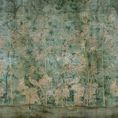 Explore Hannah’s Choice wallpaper, a serene garden scene with delicate pastel blooms, tall bamboo, and perched birds on twisting branches. The background is an aged, muted green offering timeless nature. Faded yet intricate patterns add vintage charm. Colors include soft pinks, light blues, natural greens, and gentle yellows against the muted green canvas. This elegant design captures the essence of vintage tranquility for those seeking a touch of nature indoors.