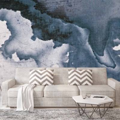 The backdrop features an abstract mural resembling an ink cloud formation in shades of blue and white. Elements include fluid, swirling patterns, with various blues blending seamlessly into white, creating a mesmerizing and dynamic focal point. The design evokes movement and depth, reminiscent of watercolor or cloud-like dispersion.