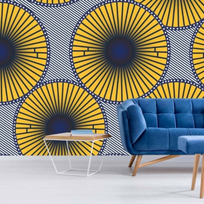 The wallpaper features a vibrant geometric sunburst pattern in yellow, blue, and black from Nelson's Threads collection.