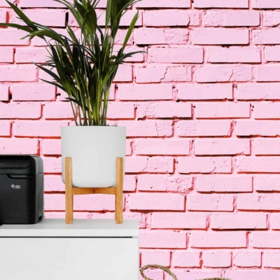 The wallpaper features a pink-painted brick pattern reminiscent of the Pink Panther's signature hue. The color is a distinct and vibrant pink, giving a playful and nostalgic feel to the background.