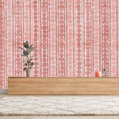 The room features a modern aesthetic with a striking red and white patterned wallpaper. The vivid red contrasts sharply against the crisp white, creating an eye-catching backdrop. Geometric and intricate designs dominate the wallpaper, adding a layer of visual complexity that enhances the minimalist decor. This bold choice of colors and patterns sets a dynamic tone for the space.