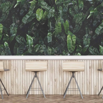 The wallpaper is a lush, green leafy wall. It features dense foliage in various shades of green, creating a vibrant and natural ambiance. The leaves vary in shape and size, adding depth and texture to the space.