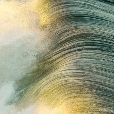 A close-up photograph of a dynamic ocean wave crashing, illuminated by sunlight casting a golden hue on swirling water. The vibrant motion is captured with shimmering blues and iridescent whites, contrasted by warm gold touches—an inspiring reminder to seize the day. This wallpaper includes elements of water movement, sunlight reflection, and ocean energy with hues of blue, white, and gold.