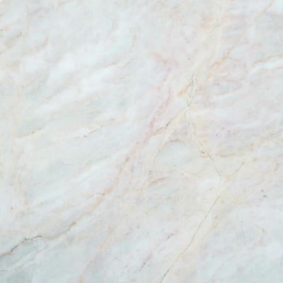 A close-up view of a light-colored marble surface with subtle veining in shades of beige, cream, and soft pink. The texture is smooth, with natural patterns creating an elegant, polished appearance. Highlights include delicate lines in beige, cream, and soft pink tones.