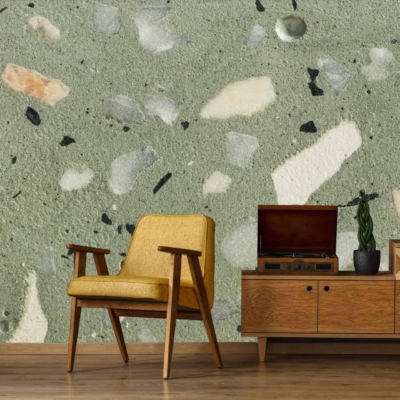 Terrazzo-patterned wallpaper with shades of green and beige. Elements include fragmented shapes in varying sizes, creating a textured and dynamic backdrop.