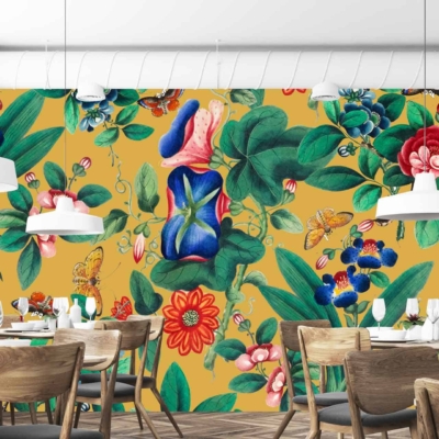 A vibrant, floral mural with large green leaves, colorful flowers, and abstract shapes against a mustard-yellow background. Reminiscent of travel to Valencia, Spain.