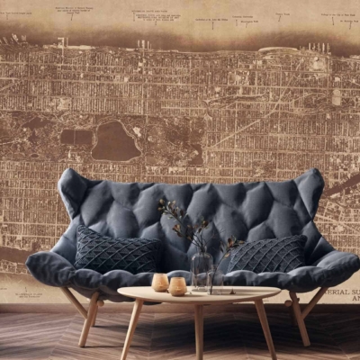 The wallpaper displays a vintage map of NYC, specifically highlighting Manhattan and the Bronx. It features intricate details of streets and landmarks with sepia-toned hues, muted greens, soft blues, and aged parchment colors. A decorative compass rose adds a classic touch in faded gold tones.