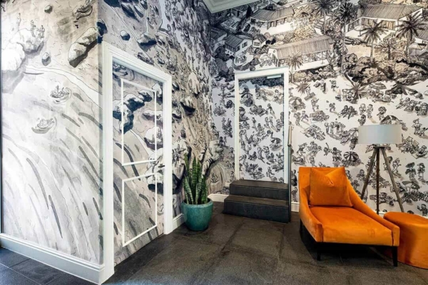 Wallpaper features intricate black-and-white wall art depicting architectural and natural scenes.