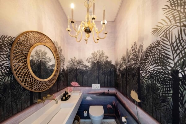 The bathroom's nature-themed wallpaper features lush tropical palm trees and a serene landscape. Green hues of the palm fronds, various shades of blue for the tranquil sky and water, and earthy browns create a calming natural environment perfect for this small space.