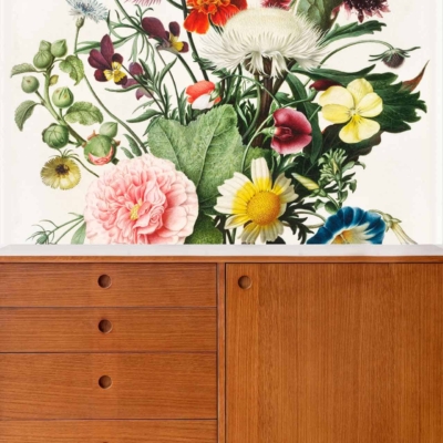 The wallpaper is a vibrant floral mural featuring an array of colorful posies and green foliage. It includes a variety of hues such as reds, pinks, yellows, blues, and greens, creating a lively and artistic backdrop.
