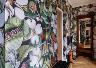 The hallway's wallpaper is vibrant, featuring large white flowers and colorful blooms with lush green leaves.