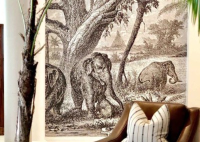 The wallpaper features a serene natural landscape with elephants, showcasing earthy browns, soft greens, and muted blues. The elephants are detailed against a backdrop of lush foliage and expansive skies, creating an artistic blend of nature-inspired hues.