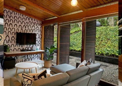 The wallpaper in the cozy living room features black arches, creating a bold and stylish pattern. The interplay of dark tones against the light backdrop adds depth and character to the space. Perfect for enhancing contemporary designs with its striking yet sophisticated look.