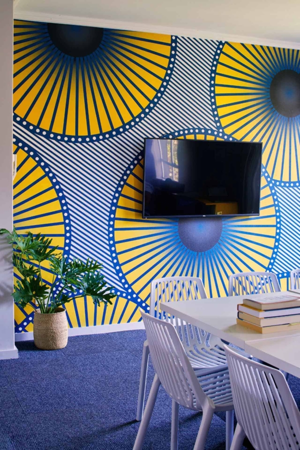 Modern room wallpaper: vibrant yellow and blue, large circular designs, bold patterns.