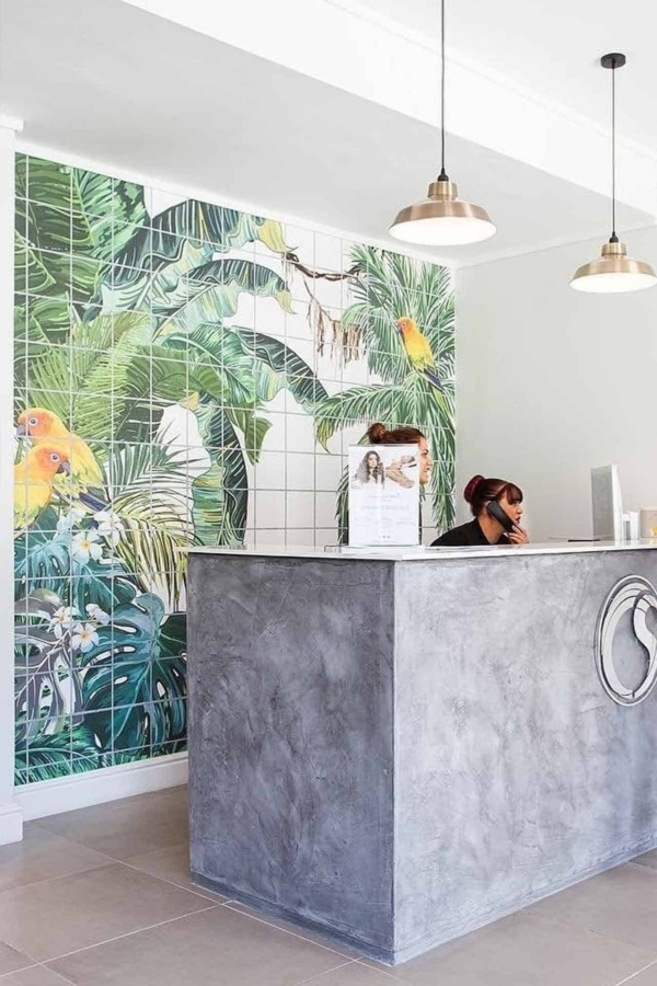 Vibrant, tropical-themed mural featuring lush green foliage and diverse birds. Rich shades of green, pops of vivid blues, striking reds, and radiant yellows dominate the design. Elements include exotic plants with broad leaves and detailed bird species like parrots and toucans adding dynamic splashes of color against a verdant backdrop.