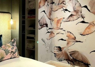 The wallpaper features an artistic mural of flying birds, showcasing shades of blue, white, and gray against a soft sky background.