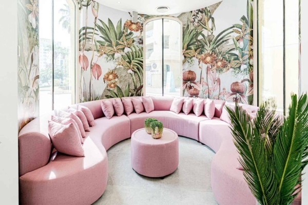 The walls feature vibrant floral and botanical wallpaper. Elements include a lush array of flowers and plants in a spectrum of colors: deep greens, rich reds, bright yellows, vivid oranges, pastel pinks, and bold blues. This wallpaper provides a colorful backdrop ideal for highlighting personal projects.