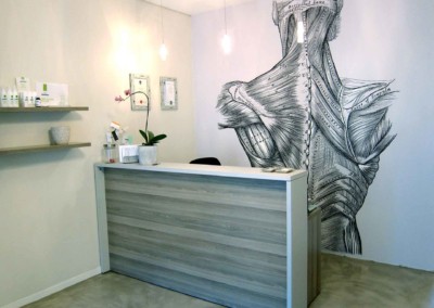 The wallpaper features an elegant black-and-white anatomical drawing of human neck and upper back muscles. The colors are monochromatic, emphasizing intricate lines and detailed shading.