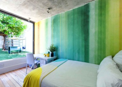 The wallpaper in this modern bedroom features a gradient green design, transitioning from deep emerald at the base to a lighter, serene mint towards the top. Subtle patterns of delicate leaves and abstract flora in various shades of green add texture and sophistication. This stylish wallpaper is perfect for creating a tranquil, nature-inspired ambiance.