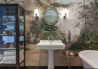 The wallpaper features a detailed mural of an outdoor scene with people and lush greenery. It includes elements like trees, bushes, and figures in period clothing. Dominant colors are green, blue, and earthy tones.