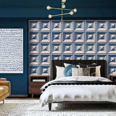 The geometric accent wall behind the bed features a striking mix of bold shapes and lines, incorporating colors such as black, white, grey, and gold. The design is modern with intersecting triangles creating a dynamic pattern that contrasts beautifully against the room's dark blue walls. The sharp lines and elegant colors of black, white, grey, and gold make this wallpaper a focal point in the room's decor.