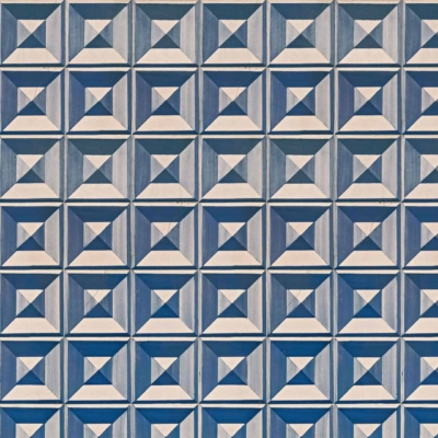 The wallpaper features a repeating geometric pattern of raised square tiles, each divided into four smaller triangular sections. The grid of diamond shapes is in varying shades of blue and light grey, creating a 3D effect. Keywords: geometric pattern, raised square tiles, triangular sections, diamond shapes, blue shades, light grey shades.
