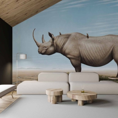 A large, realistic wall mural of a Black Rhino in a natural landscape. The wallpaper features earthy tones with hues of brown, green, and gray showcasing the rhino in its habitat. Elements include detailed textures of the rhino's skin and natural scenery like savannah grass, trees, and possibly distant mountains or sky patterning in neutral colors.