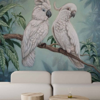 The wallpaper features a large mural of beautiful birds perched on a branch, surrounded by lush green foliage. The birds are intricately detailed, showcasing vibrant colors such as blues, reds, and yellows. The lush foliage includes various shades of green leaves and delicate flowers in pastel hues. The overall effect is natural and serene.