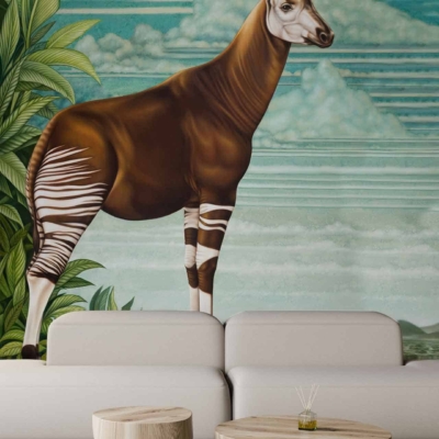 The wallpaper features a large mural of an okapi, an endangered species, standing amid a lush, green tropical background. The scene includes large leaves and a blue sky with white clouds. Key colors are green (leaves), brown (okapi), and blue (sky).