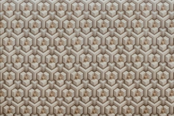 Interlocking hexagonal pattern wallpaper in shades of beige and light brown. Repetitive shapes create a 3D effect, adding depth and texture. Complex geometric design for a unique look.