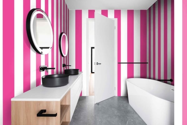 Modern bathroom features The Right Stripe wallpaper with bold vertical stripes in pink and white.