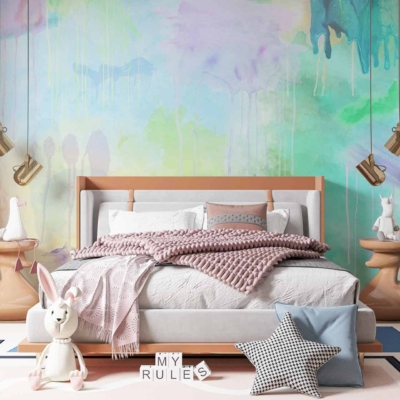 The wallpaper is a large abstract mural with dripping paint effects. It features vibrant colors including pastel hues such as soft pink, baby blue, mint green, and sunny yellow. The design is whimsical and playful, adding to the room's joyful atmosphere.
