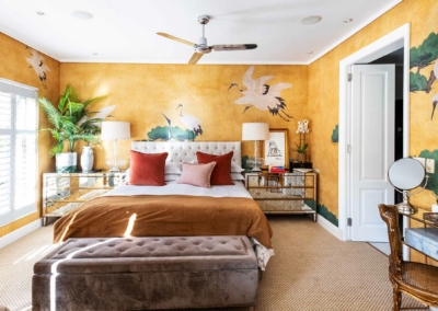 The wallpaper features warm, golden-yellow tones with elegant crane murals. The cranes are depicted gracefully, adding a touch of nature and sophistication. The mural highlights delicate details in shades of white and light gray, contrasting beautifully against the rich yellow backdrop.