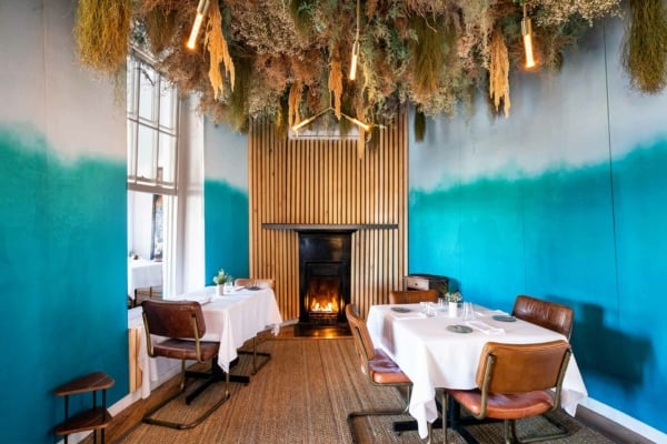 The wallpaper in the cozy dining room features a blue gradient design, transitioning from darker to lighter shades of blue.