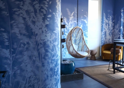 Nature-themed wallpaper, blue painted walls, white foliage silhouettes